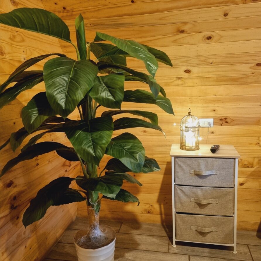 Rincón interior de la Tiny House en Olmué — farol con luces cálidas sobre la cómoda